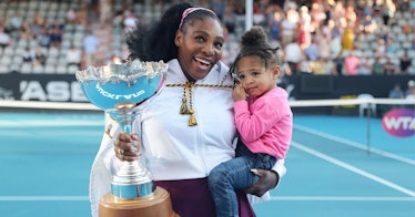 Serena Williams stands with her award and her baby