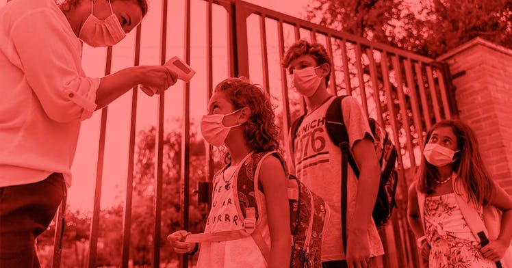 Kids in masks line up outside of a school building