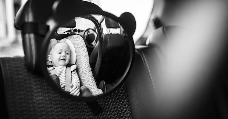 black and white photo edit of baby in her car seat reflected in a baby car seat mirror