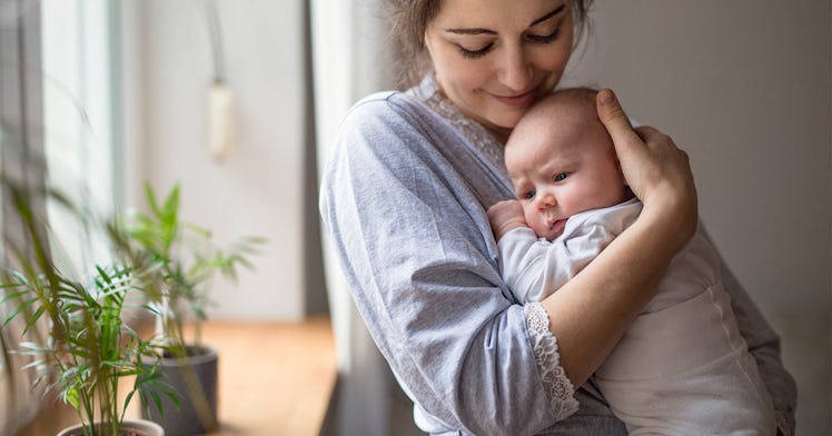 A mom holds an infant close to her chest