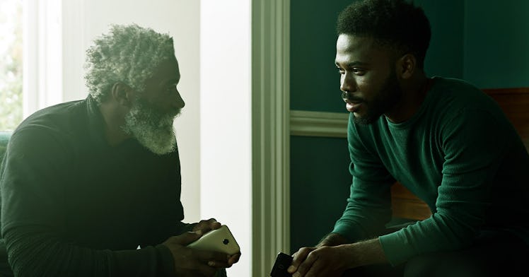 An adult son sitting across and talking to his father while preparing to lose him