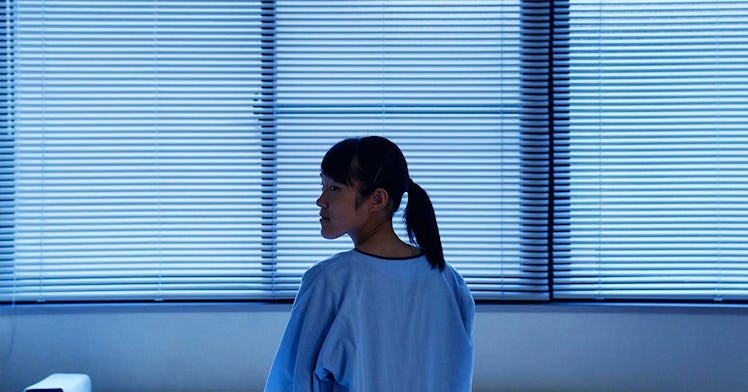 A teenager in a hospital gown