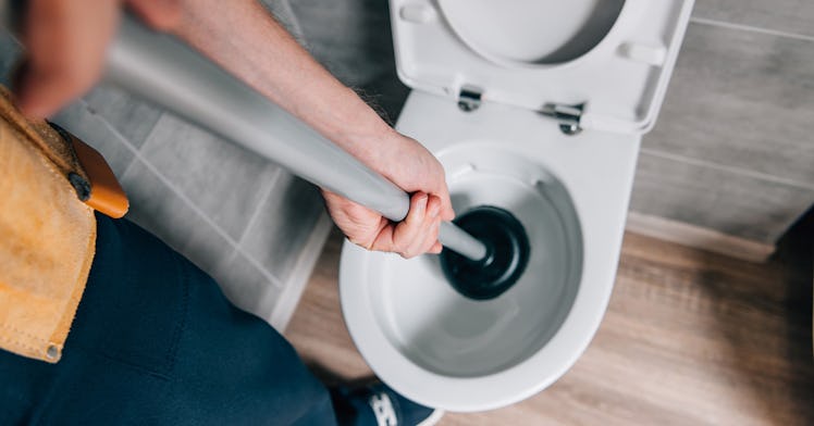 image of someone using a plunger demonstrating how to unclog a toilet