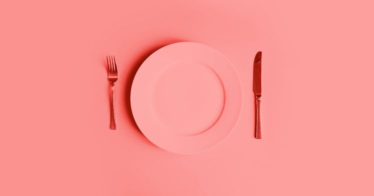 Redscale image of an empty plate with a fork to the left and a knife to the right.
