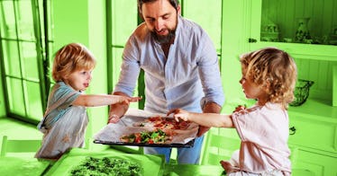 A dad handing his kids Neapolitan–like homemade pizza. 