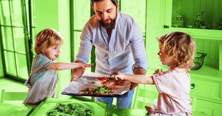 A dad handing his kids Neapolitan–like homemade pizza.