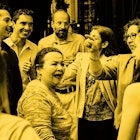 Happy people at a family gathering, dancing and talking to each other, captured through a yellow fil...