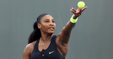 Serena Williams throws up a tennis ball