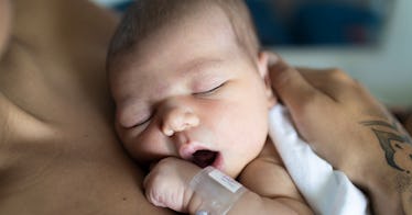 A baby yawning while laying skin to skin with a parent