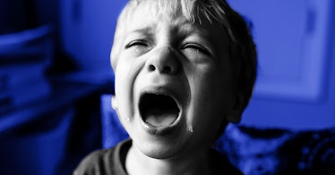 A child in distress screaming and crying with their mouth open