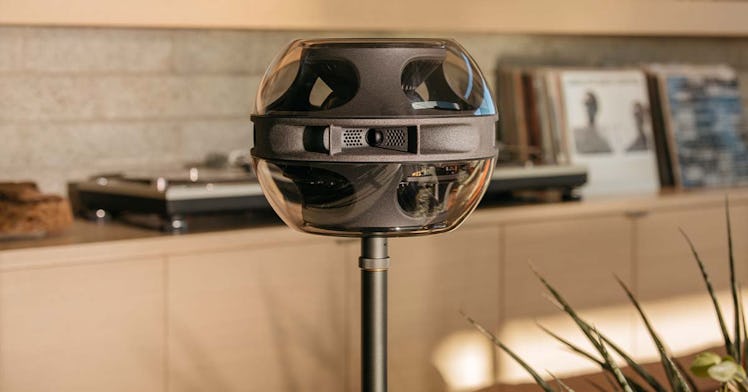 photo of Syng's Cell Alpha surround-sound speaker in a living room, with record player in the backgr...