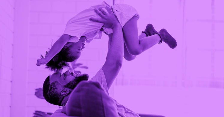 A father lying on a couch and playing with his child