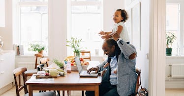 a dad and his child sit at a table; the kid is on his shoulders