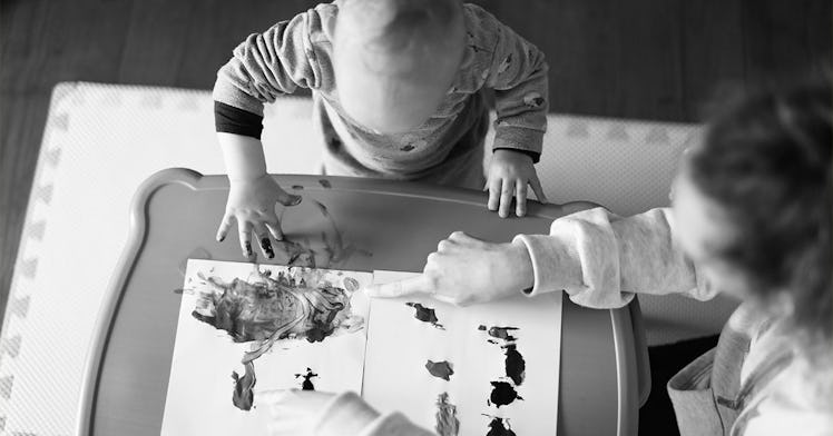 A child care worker paints with a baby