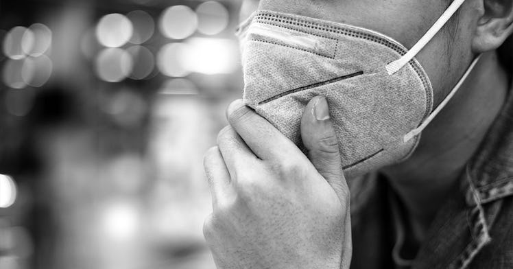 A guy wears a mask in black and white