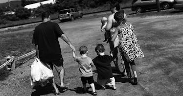 A family walks in black and white down the street