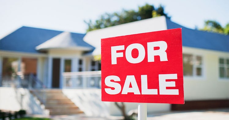A house with a 'for-sale' sign on it