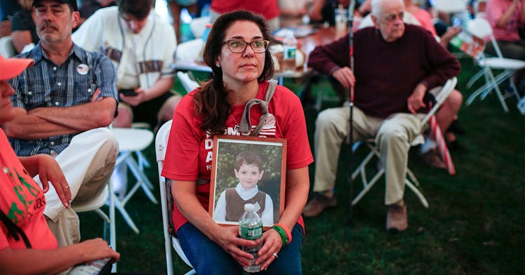 A Sandy Hook parent sits with a photo of her child