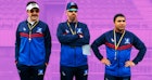 三位来自“Ted Lasso”的足球教练站在球场上，穿着蓝色追踪服，看着…