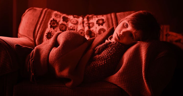 red-scale edit of a sad child lying on a couch