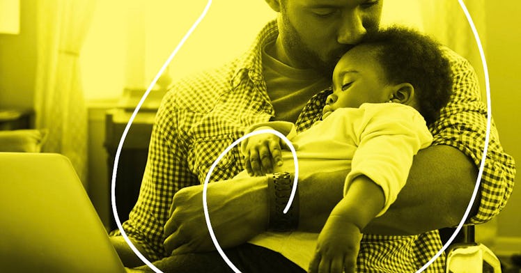 A dad embraces his child in front of a laptop. They are cast in yellow