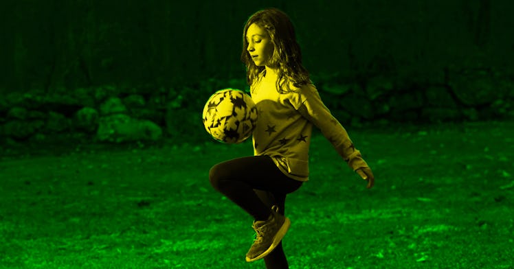 a kid practices an olympic game in their backyard