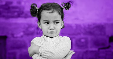 A little girl crossed her arms looking defiant and strong-willed.