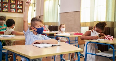 Kids wear masks in a classroom at their desks