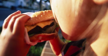 A kid eats a cheeseburger