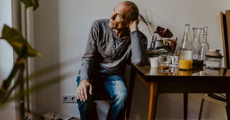 an old man sits at a table