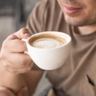 a man holds a cup of coffee