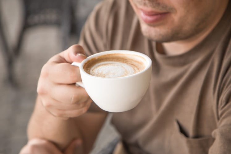 a man holds a cup of coffee