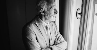 Senior citizen stares out of window