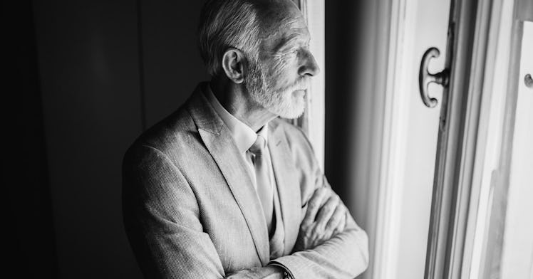 Senior citizen stares out of window