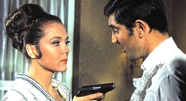 Diana Rigg pointing a gun at George Lazenby in the 1969 James Bond