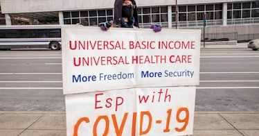 A protestor holds a sign showing his support for basic income