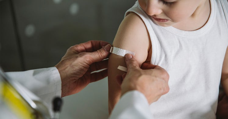 a kid gets a bandaid placed on their arm