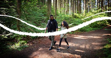 a father and daughter walk through the forest