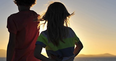 two kids with long hair face the sun