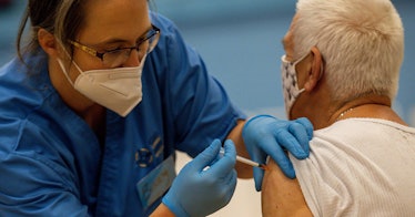 A nurse vaccinates an old person