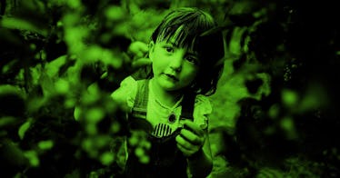 A small girl exploring leaves curiously 