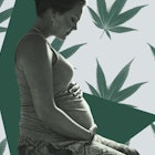 A pregnant woman holding her stomach on a blue backdrop with green cannabis leaves.