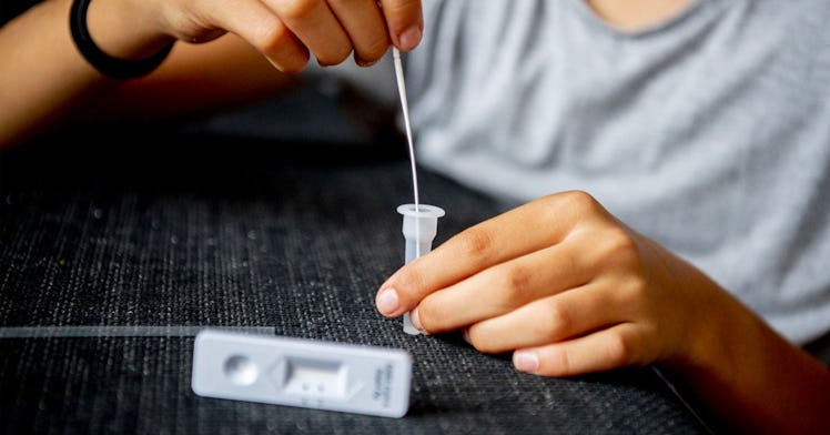A person doing an at-home COVID test before an indoor gathering