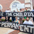 Group of parents holding a "Make the child tax credit permanent" protest sign