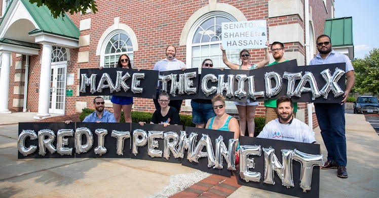 Group of parents holding a "Make the child tax credit permanent" protest sign
