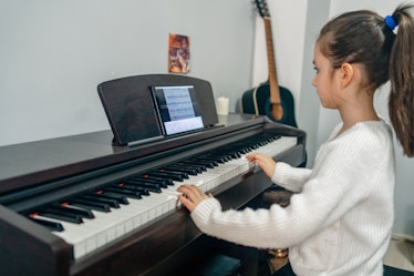 A child in music class playing a piano 