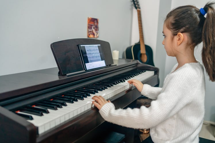 A child in music class playing a piano
