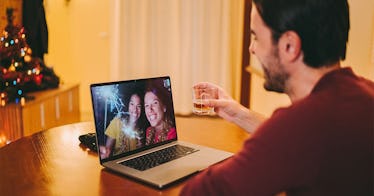 a man sits in front of his computer, Zooming with someone