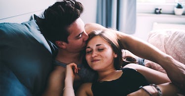 Partners lie in bed feeling confident with each other.