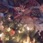 A family in their pajamas sitting near their Christmas tree.